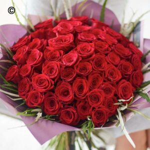 Bouquet of 50 Red Roses wrapped in purple paper.