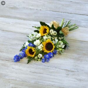 A Sunflower Sheave of sunflowers, white blossoms, and blue flowers tied with twine on a wooden surface.