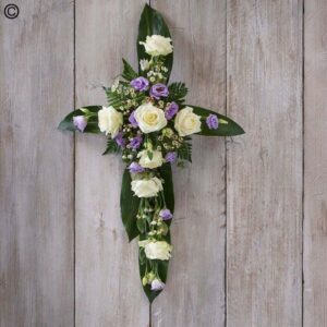 Floral petite open cross necklace arrangement with white and purple flowers against a wooden backdrop.