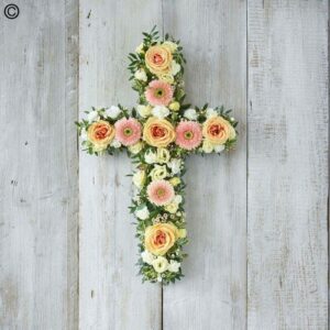 Peach Open Cross floral arrangement on a wooden background.