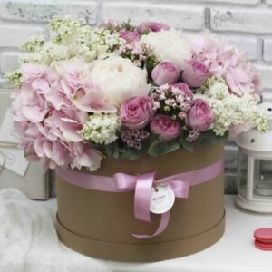 Hat Box Deluxe Pretty in Pink of pink and white flowers with a ribbon and a tag.