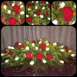 A collage showcasing a floral arrangement with red roses, white flowers, and green foliage, designed as a Tranquil Memories Casket Spray presented on a dark surface with a draped background.