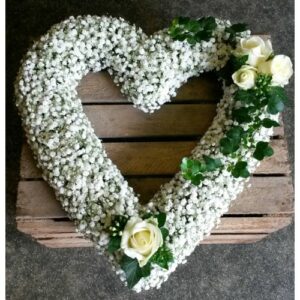 Floral arrangement in the Gypsophila Open Heart shape on a wooden background.