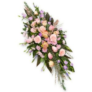 Elegant funeral flowers with pink roses and assorted blooms, a Casket Spray, on a white background.